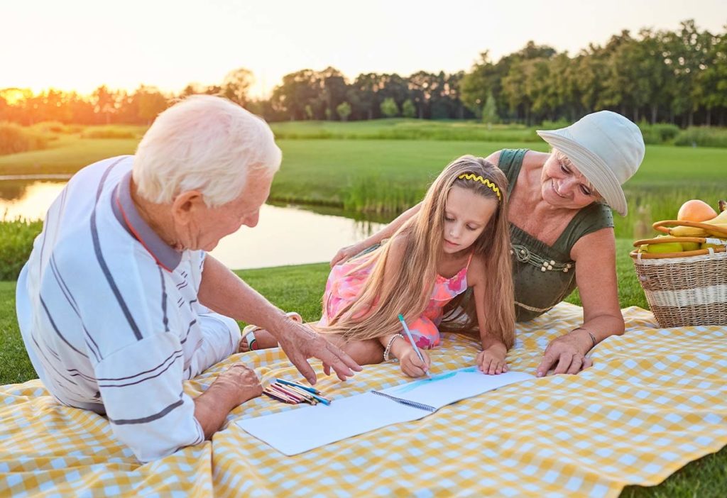 grandparents drawing with their granddaughter on a picnic blanket what is an iul policy skokie il