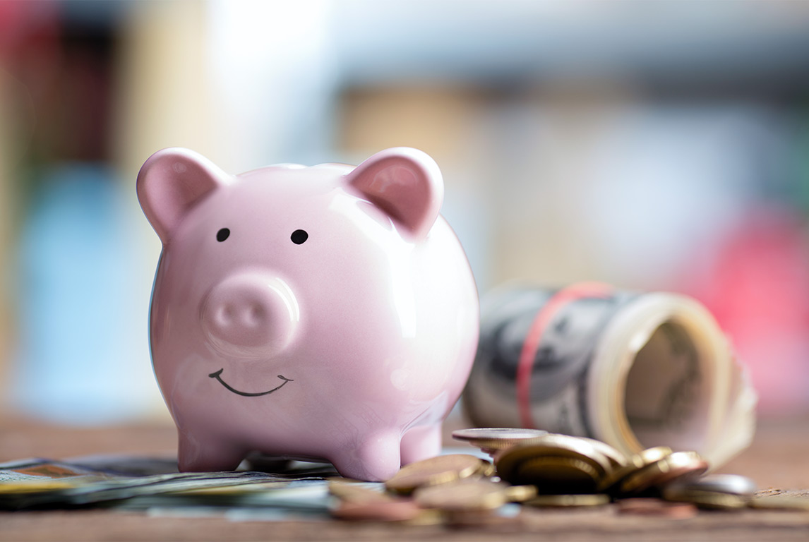 piggy bank next to coins and rolled dollar bills successful retirement strategies skokie il