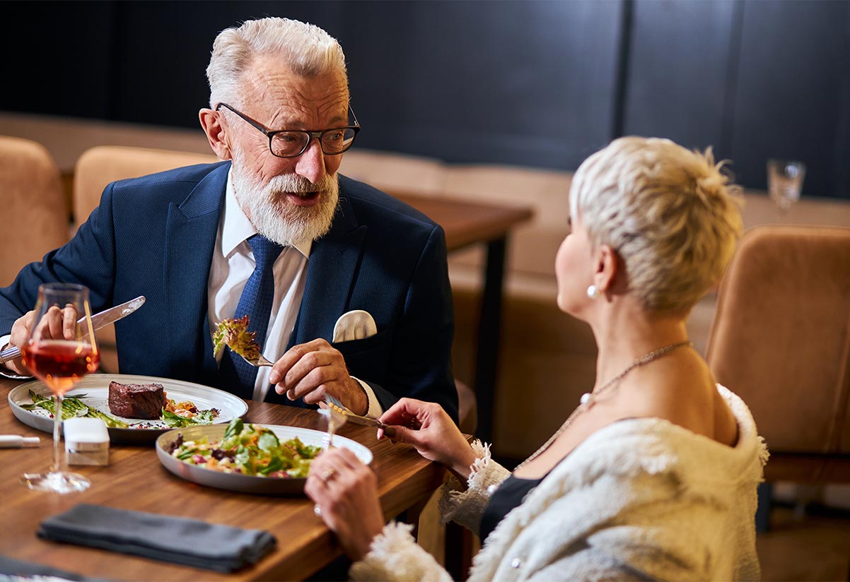 senior couple enjoying complimentary steak meal at one of our educational seminars