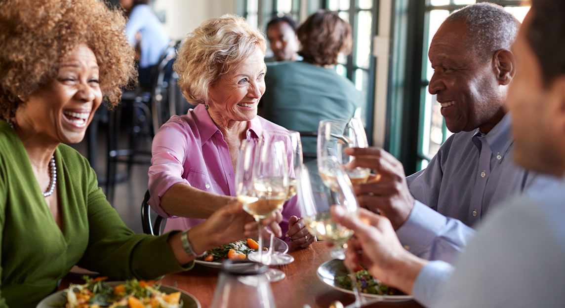 senior friends having dinner and wine together at a small restaurant options for taxes in retirement chicago il
