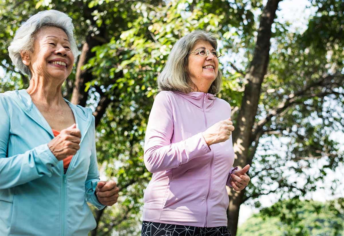 two senior women jogging together with big smiles on their faces taxes in retirement life insurance options chicago il