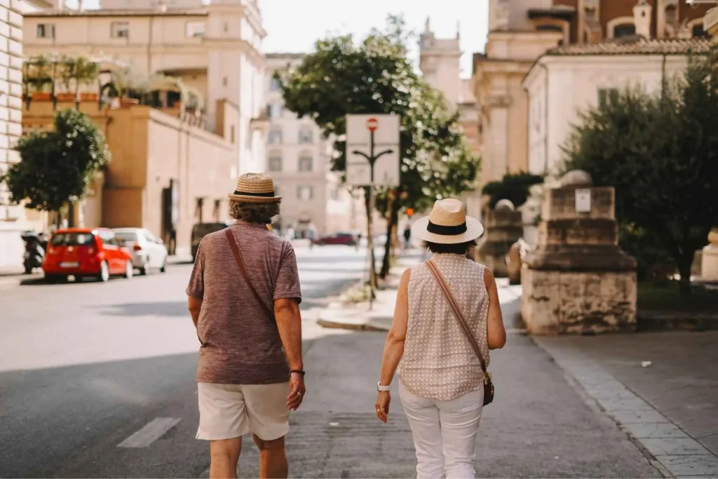 A retired couple enjoying a peaceful walk through a European city, symbolizing financial freedom in retirement.